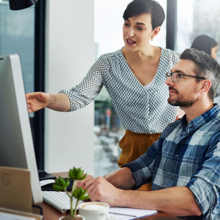 人間の翻訳者二人がパソコンの前で翻訳を作っている。